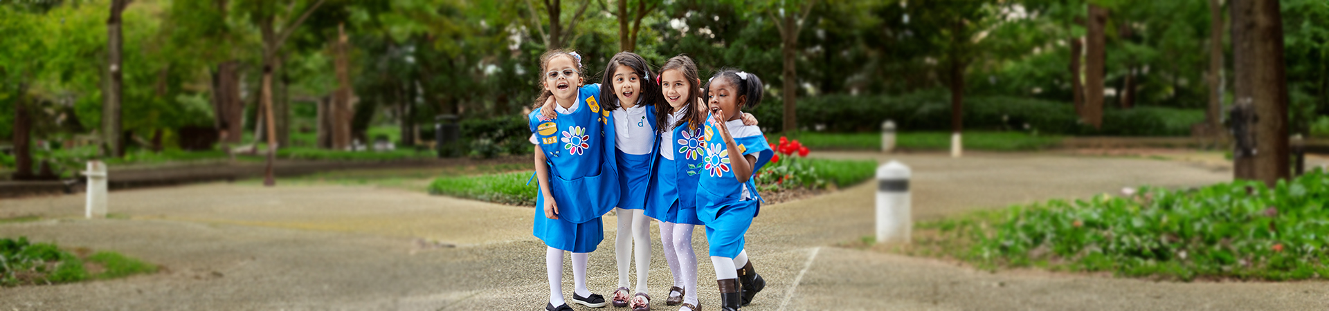  four Daisies wearing their uniforms with their arms around each other 