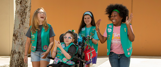 Four Junior Girl Scouts laughing