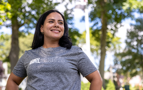 Women in gray T-shirt stand outdoors