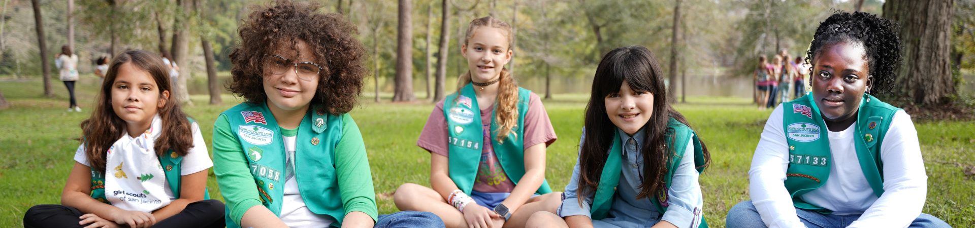  young girls making poster with text that reads action now girl scouts 